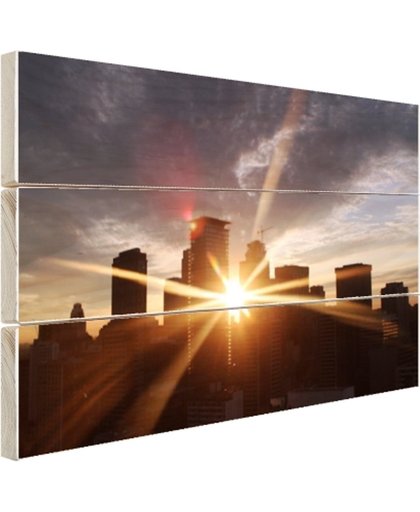 FotoCadeau.nl - Stralen ondergaande zon door gebouwen Hout 30x20 cm - Foto print op Hout (Wanddecoratie)