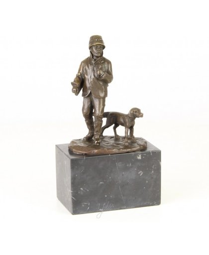 Een bronzen beeld van een jager met zijn hond